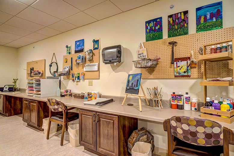 Art studio with various painting supplies and completed artworks on display.