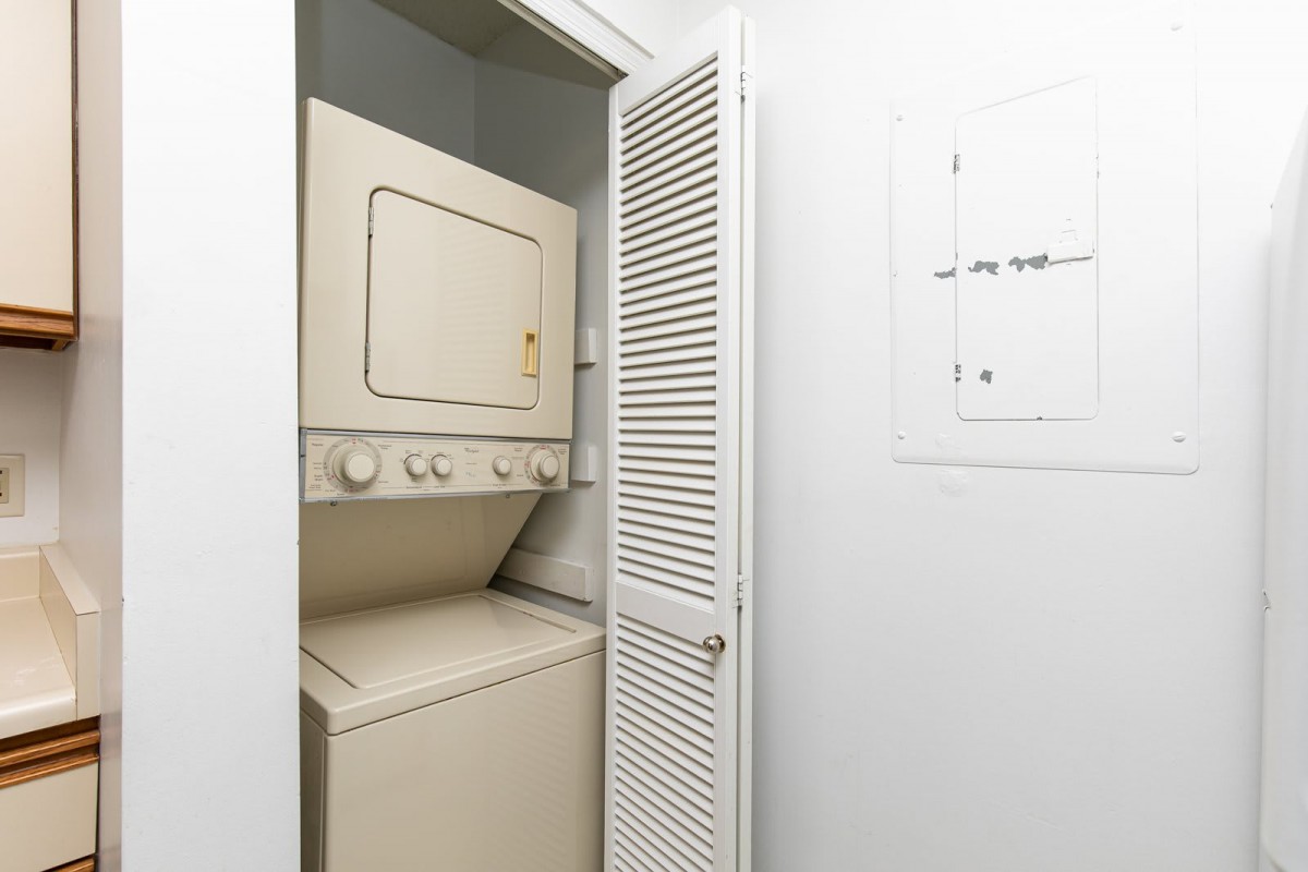 A small laundry area with a stacked washer and dryer in a closet.