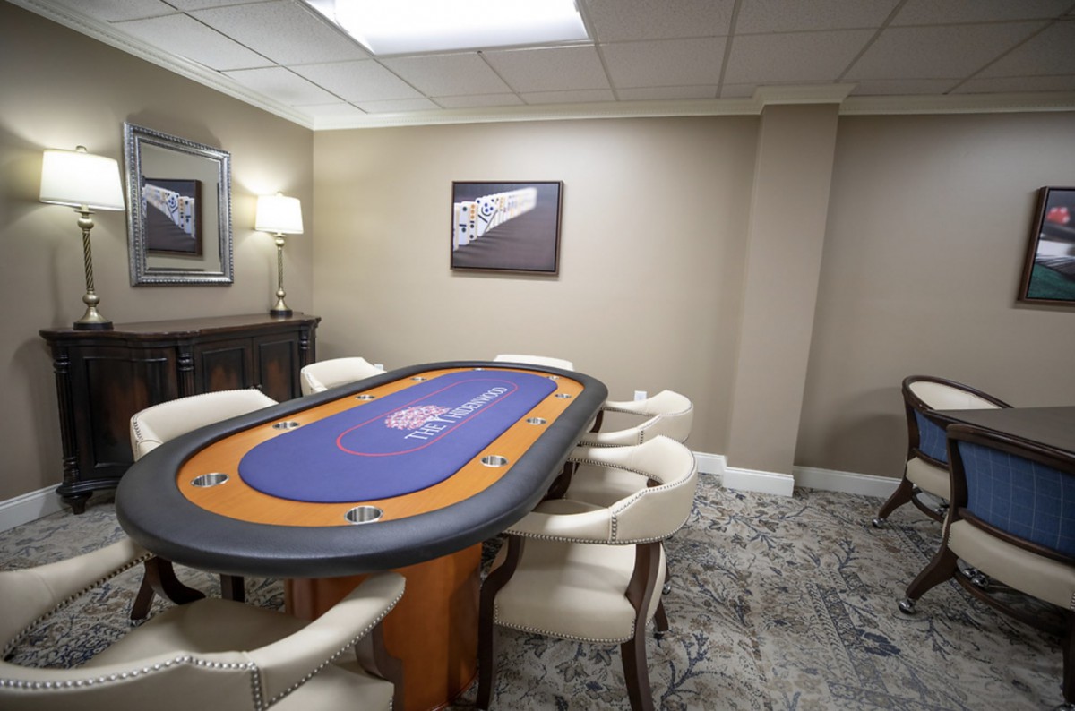 A luxurious game room featuring a poker table surrounded by comfortable chairs.