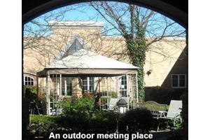 A cozy outdoor meeting place with a gazebo and garden furniture.