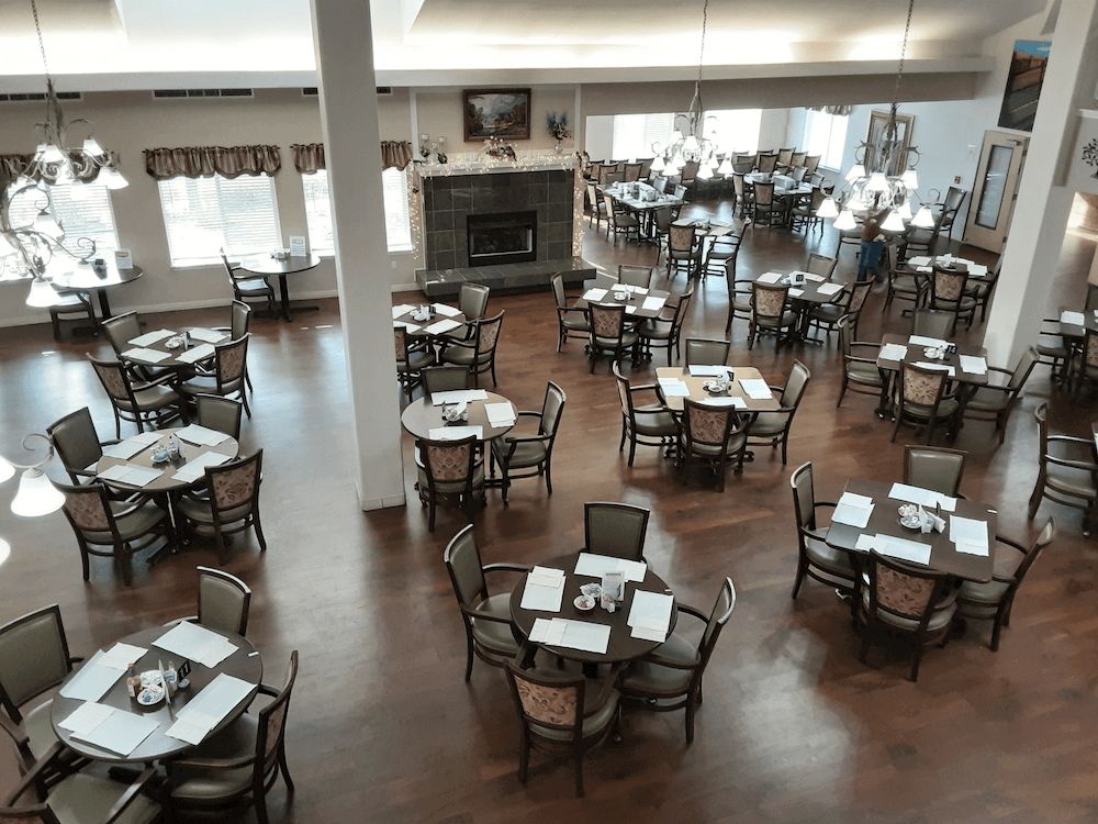 An empty dining room with multiple tables and chairs arranged neatly.
