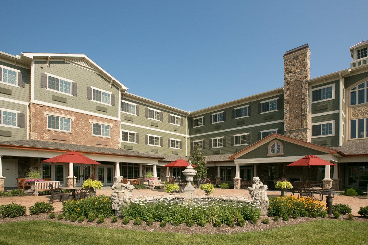 A well-maintained hotel with a landscaped garden and outdoor seating area.