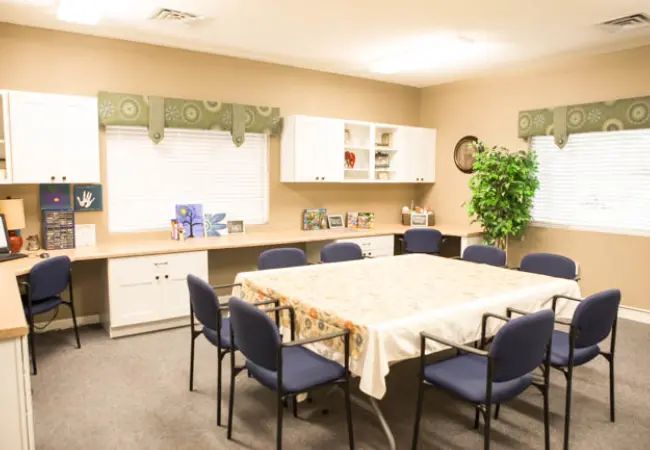 A well-lit meeting room with a conference table, chairs, and office decor.