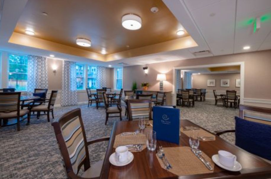 A cozy and elegant dining room with neatly set tables and warm lighting.