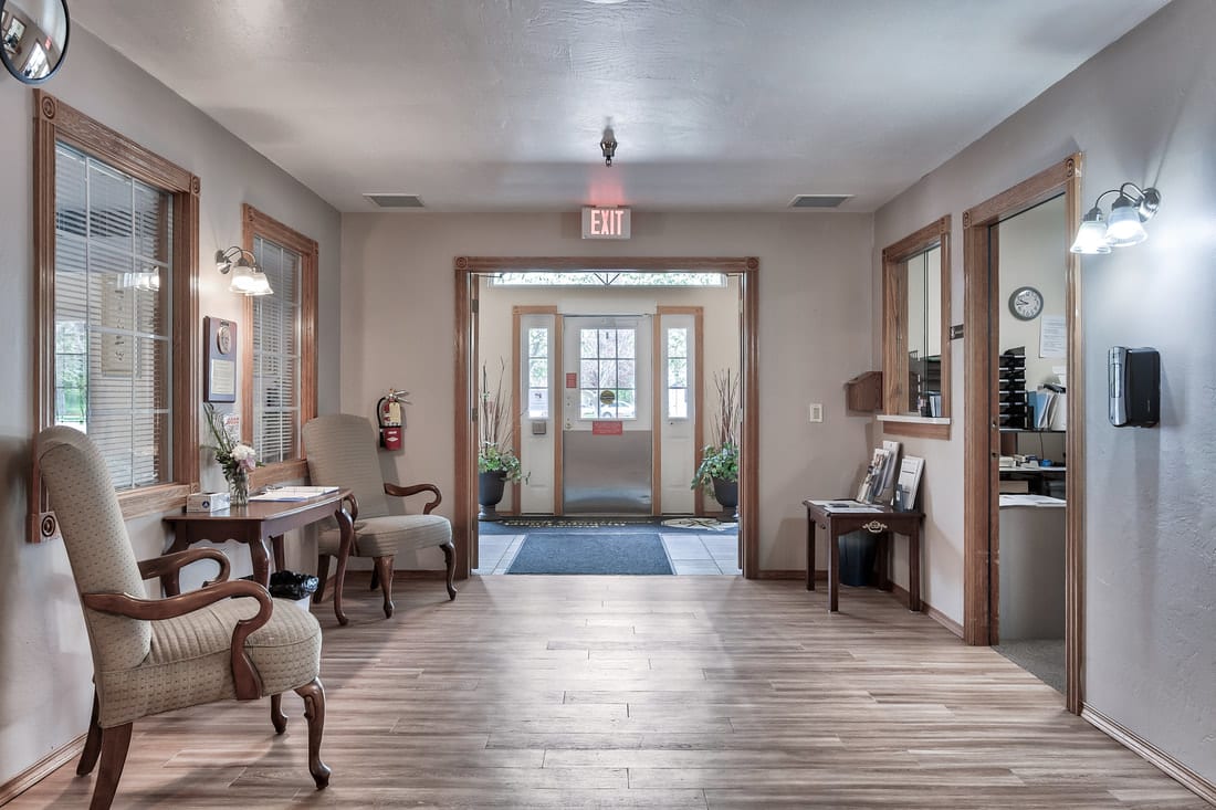A warmly lit lobby area with comfortable seating and wooden flooring.