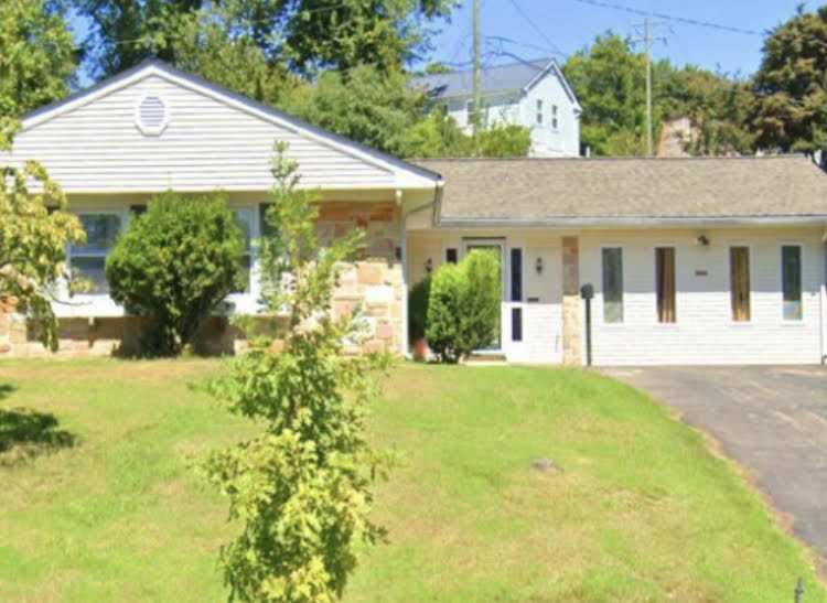 A suburban house with a spacious lawn and driveway.