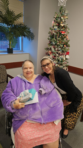 A joyful moment between two friends during the holiday season, surrounded by festive decorations.