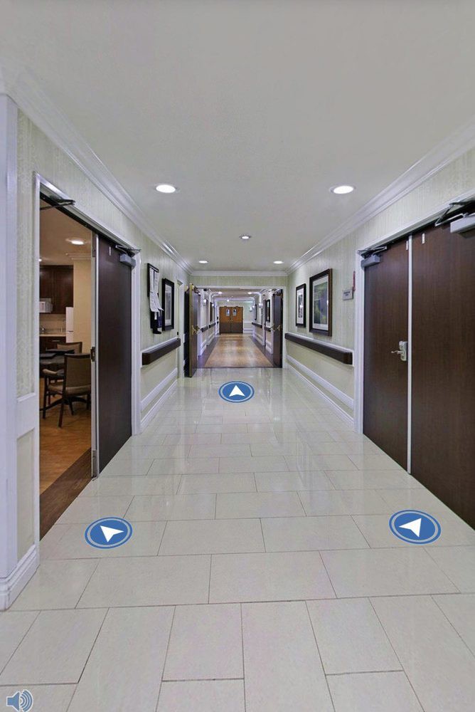 A modern, well-lit indoor hallway with multiple doors and tiled flooring.