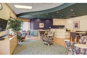 A modern waiting room with comfortable seating and decorative plants.