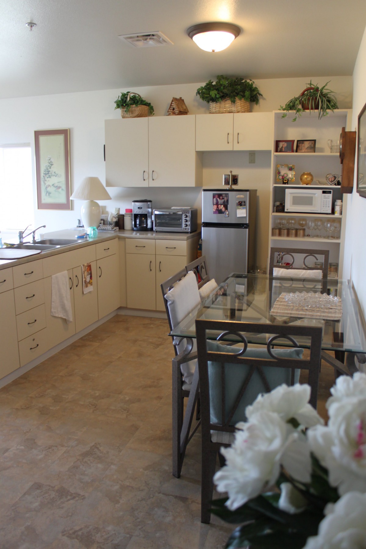 A cozy kitchen and dining area featuring modern appliances, white cabinets, and elegant decor.