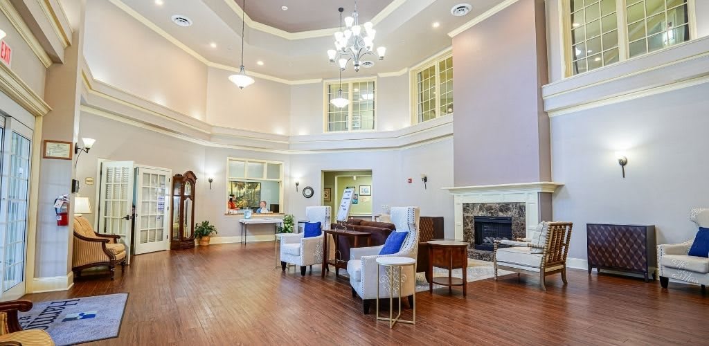 A spacious, elegantly designed living room with a chandelier and fireplace.