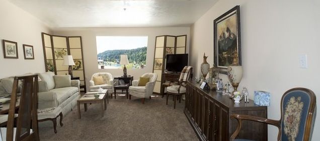 A cozy living room featuring comfortable seating with a scenic view through a large window.