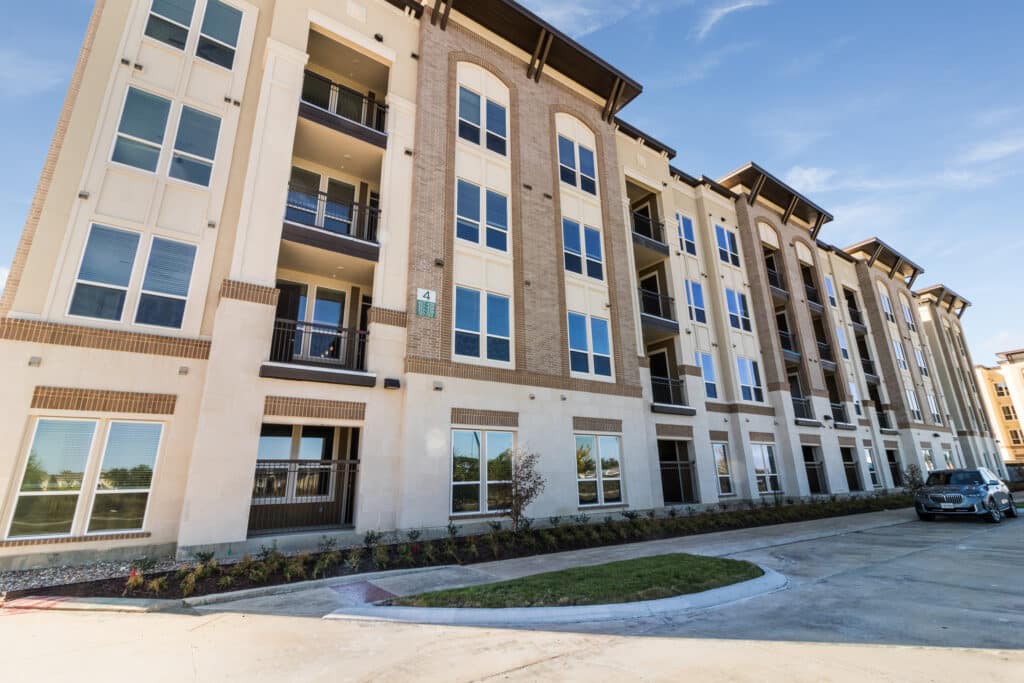 A modern multi-story apartment building with a well-maintained exterior.