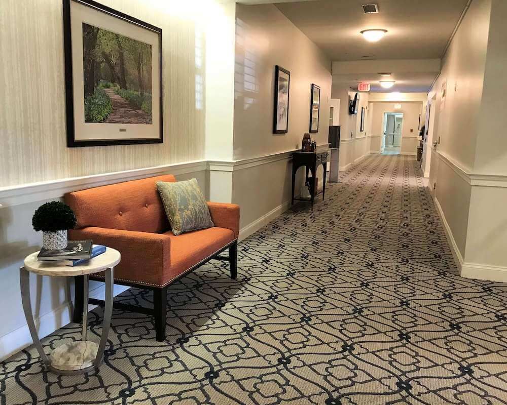 A well-decorated hallway with a seating area and artwork on the walls.