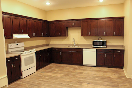 A modern kitchen with wooden cabinets and essential appliances.