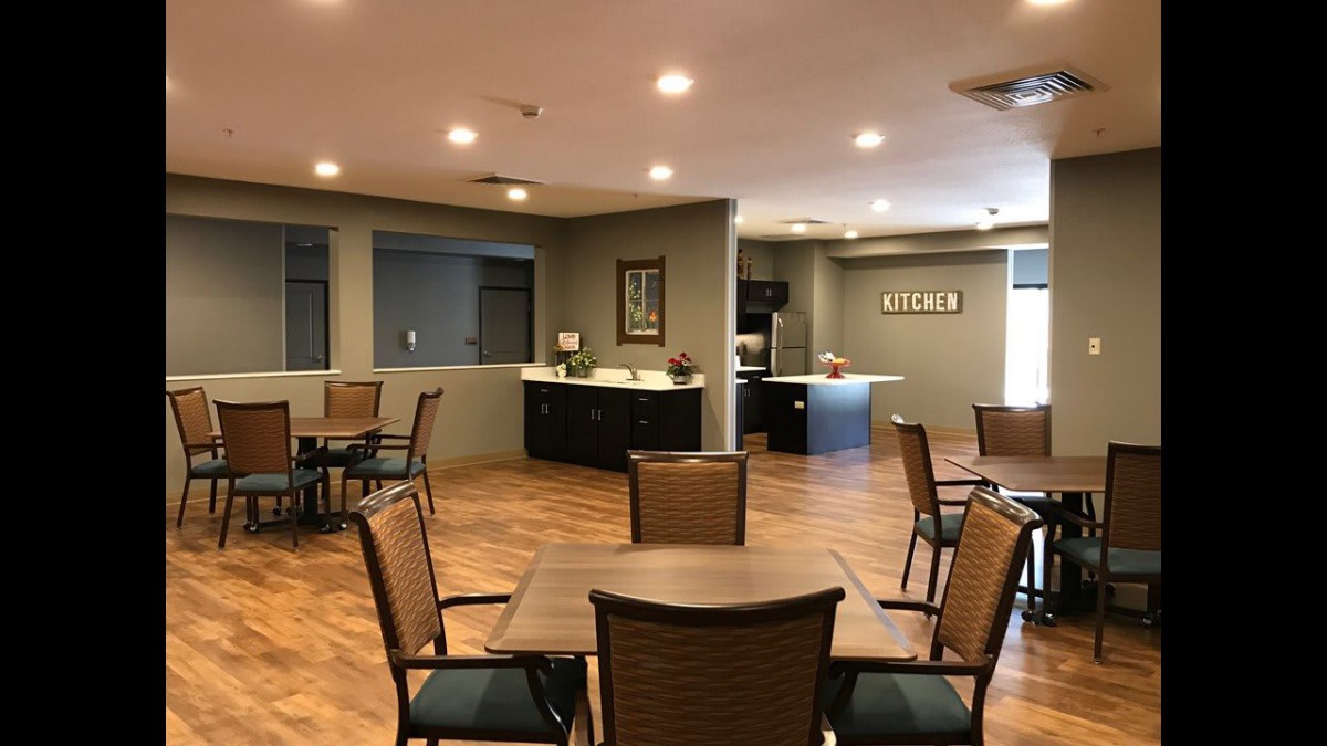A view of a modern seating area with tables and chairs, featuring warm lighting and a welcoming atmosphere.