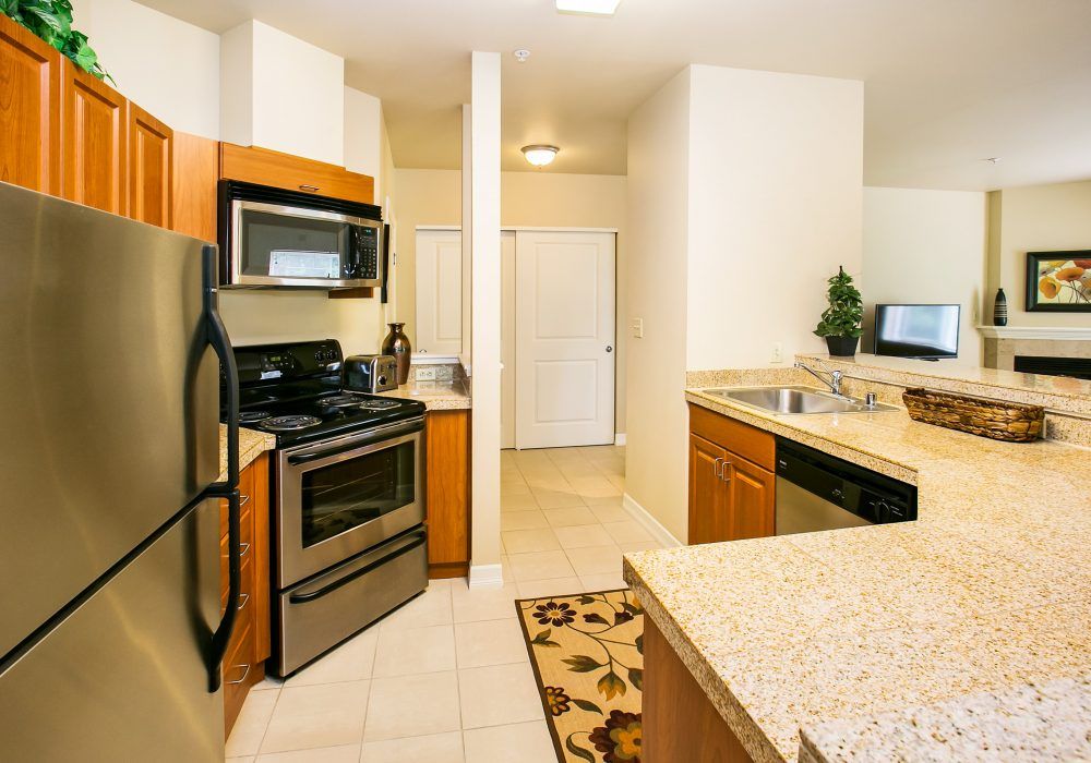 A modern kitchen with stainless steel appliances and granite countertops.