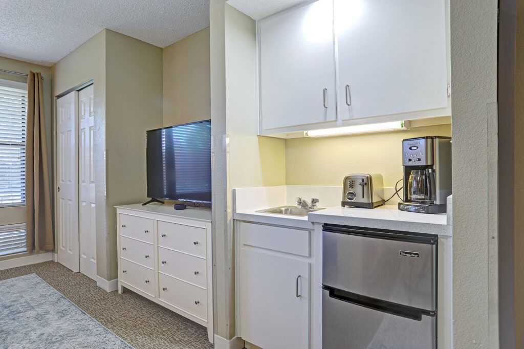 A modern kitchenette with a TV and appliances.