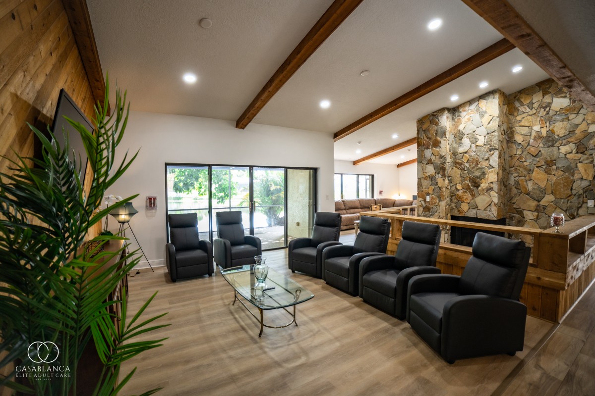 A modern living room featuring leather seating, a glass coffee table, and decorative wooden beams.