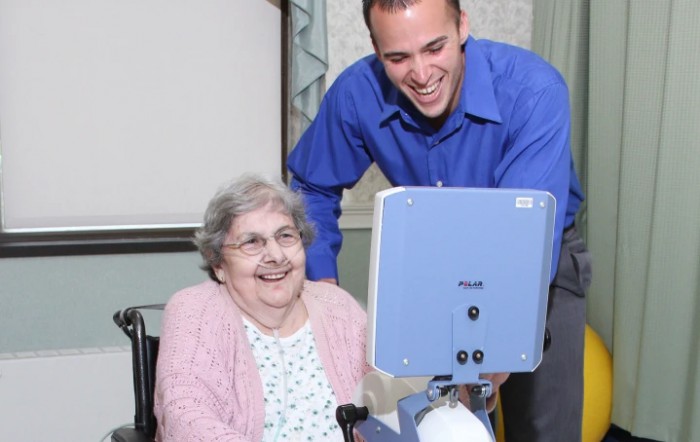 A young man shares a moment of joy with an elderly woman, engaging with technology.