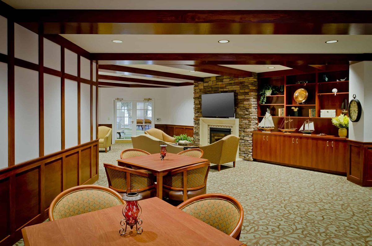 A cozy lounge area featuring comfortable seating, a fireplace, and a television.