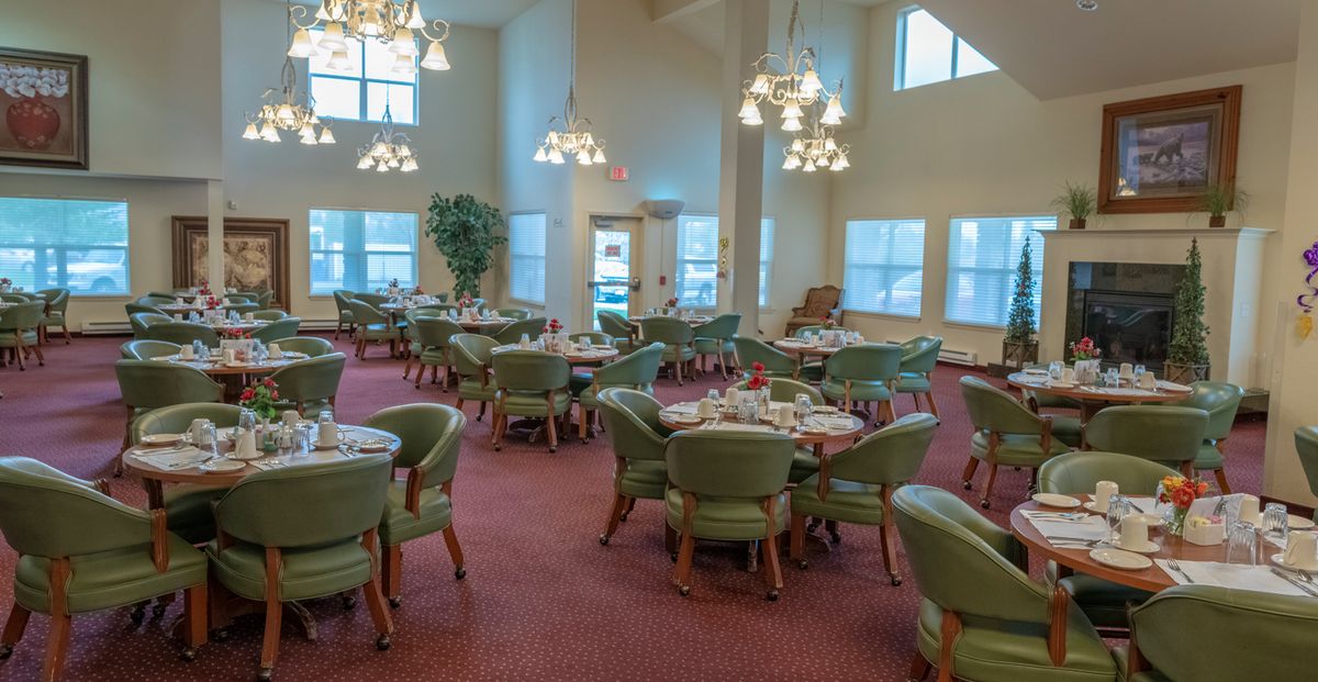 A well-lit dining area with multiple tables and chairs arranged neatly.