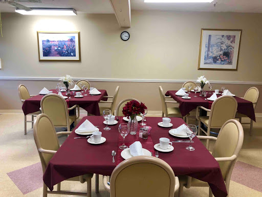 A beautifully arranged dining area featuring tables set with elegant dishware and decorative flowers.