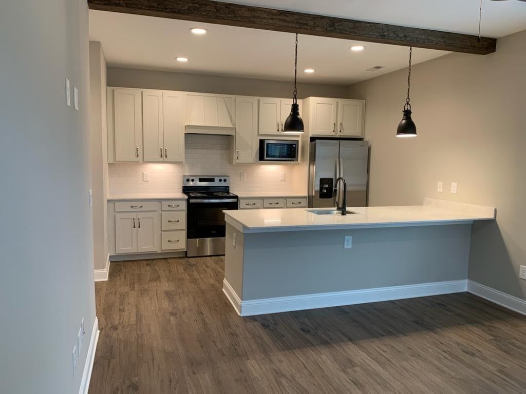 A modern open-concept kitchen with pendant lighting and stainless steel appliances.