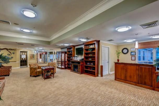 A spacious living room interior with bookshelves, a TV, and comfortable seating.