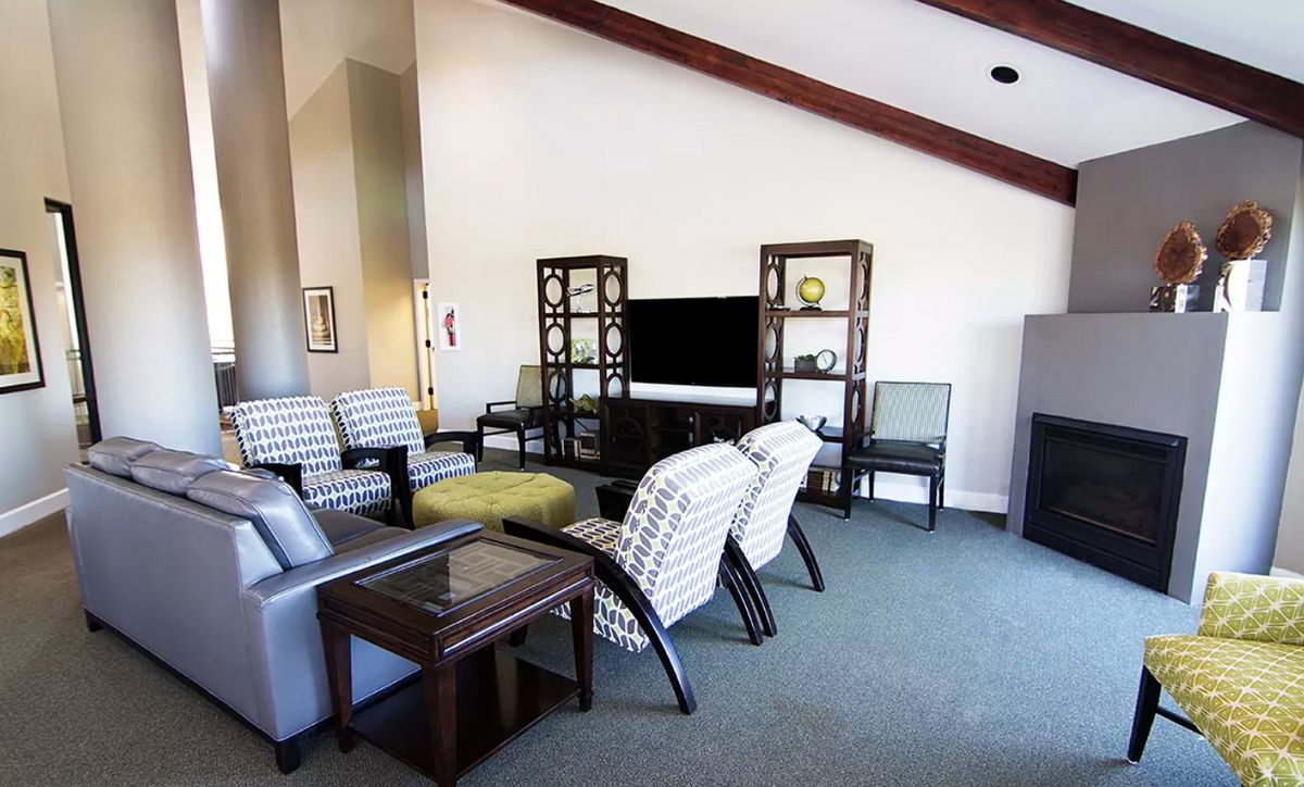 A modern living room with stylish furniture and a large television.