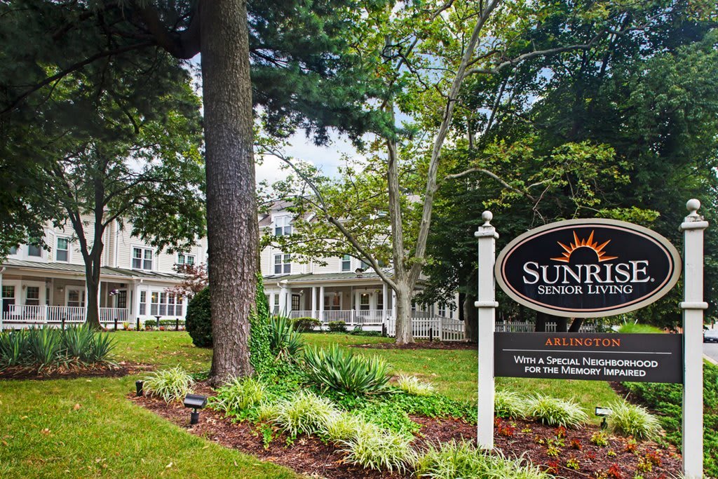 A scenic view of a building with a sign and lush greenery.