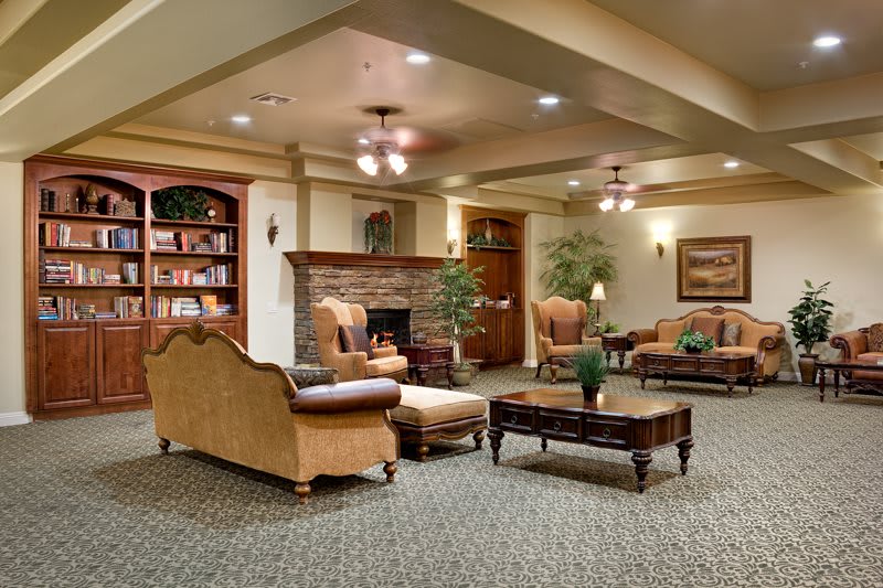 A cozy living room with a fireplace, comfortable seating, and a bookshelf.