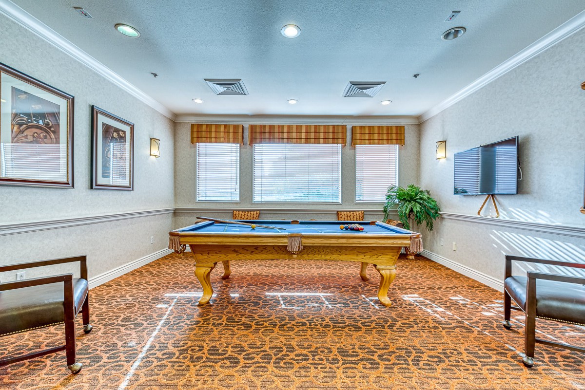 A well-lit billiards room featuring a pool table and stylish interior decor.