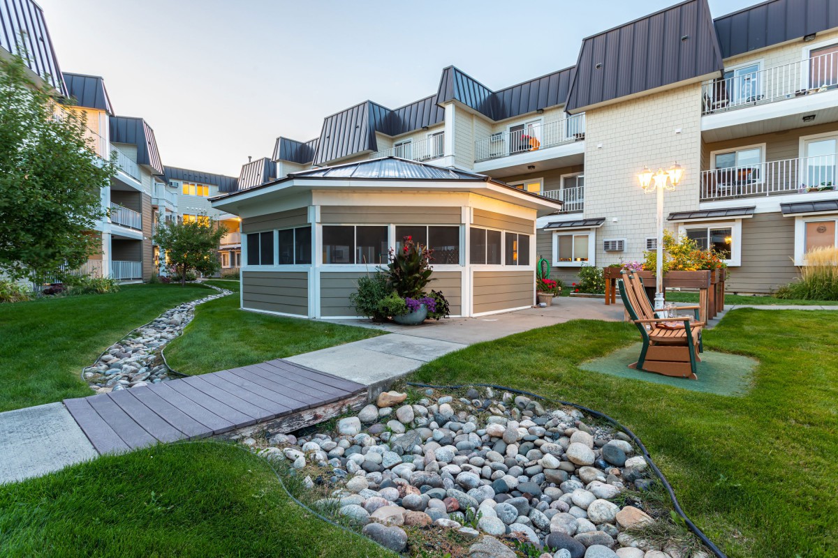 A modern building surrounded by a landscaped garden with a rocky pathway.
