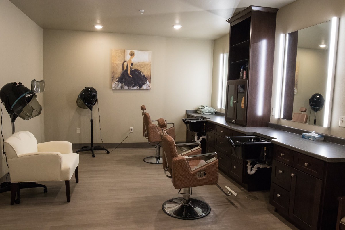 Modern barbershop interior with styling chairs and mirrors.