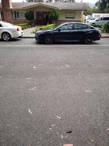 A black car parked alongside a white car on a city street.