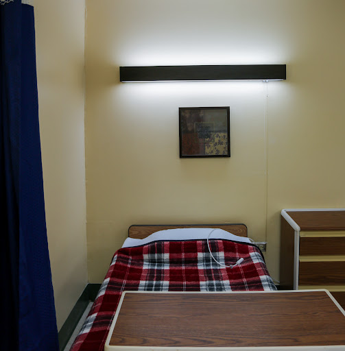 A simple room with a bed, a light fixture, and minimal furniture.