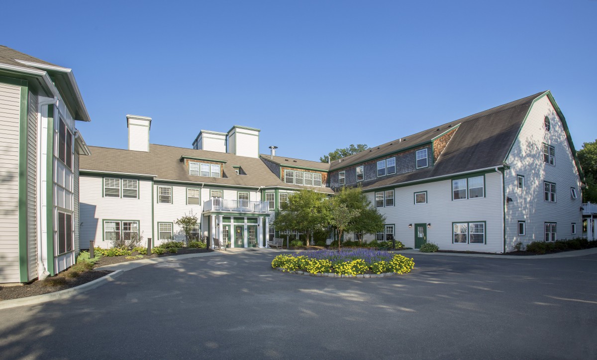 A view of a hotel building with a clear blue sky and surrounding greenery.