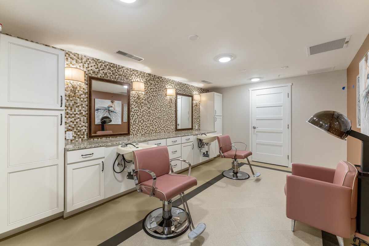 A contemporary beauty salon interior with stylish chairs and well-lit mirrors.