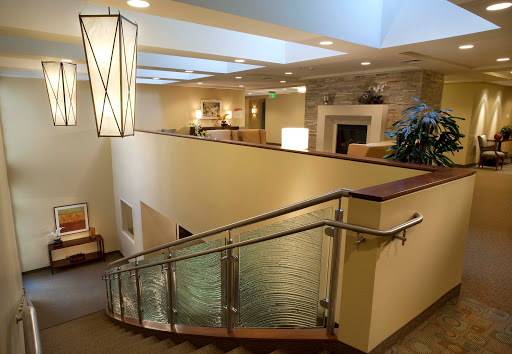 A spacious and inviting interior lobby featuring elegant lighting and a gracefully curved staircase.