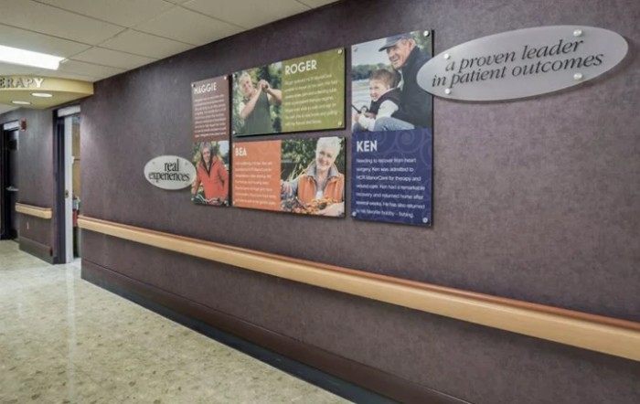 A hospital hallway decorated with informational posters on the wall.