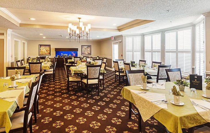 An elegantly decorated dining room with neatly arranged tables and a chandelier.