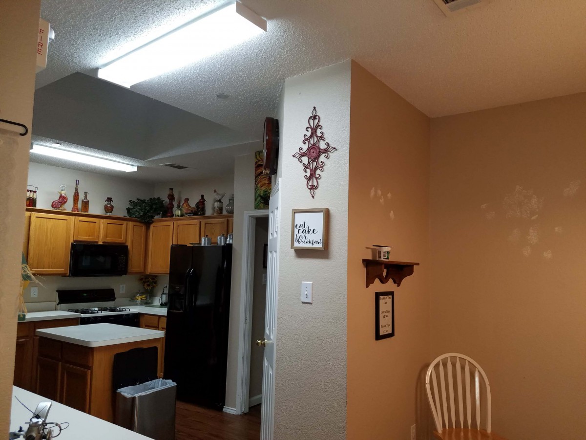 A cozy kitchen with wooden cabinets and modern appliances, adorned with home decor.