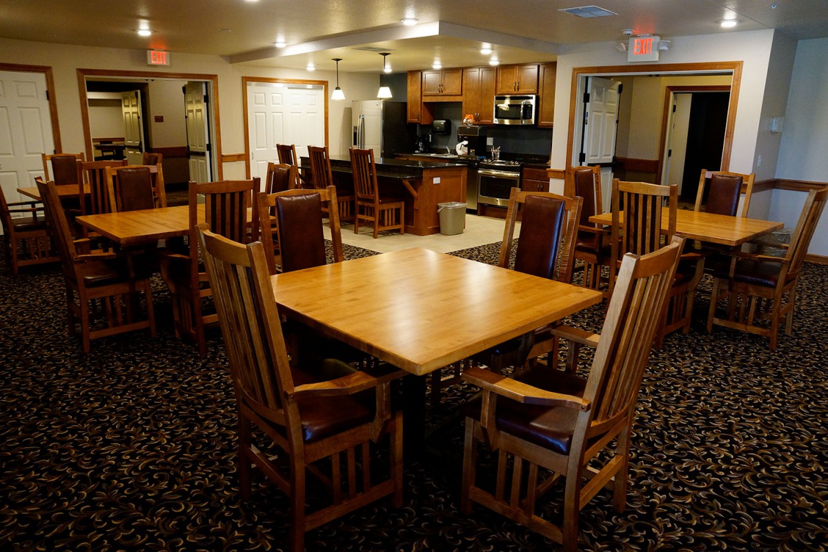 A cozy dining area with wooden tables and chairs, featuring a warm interior design.