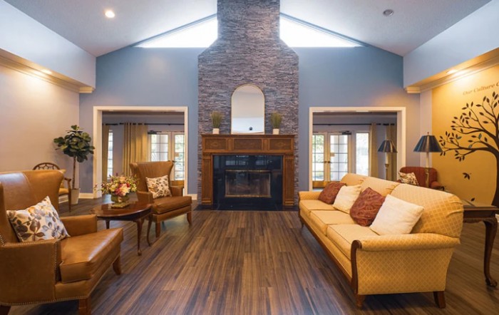 A cozy living room featuring a fireplace, vaulted ceiling, and comfortable seating.