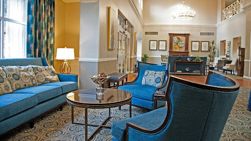 A stylish and inviting lobby seating area featuring blue chairs and a coffee table.