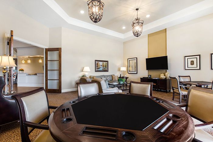 A luxurious game room featuring a poker table and stylish furnishings.