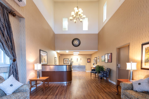 A spacious and welcoming lobby featuring a reception desk, elegant chandelier, and comfortable seating.