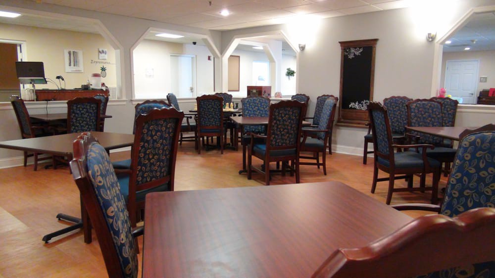 A spacious dining room with several tables and chairs arranged neatly.