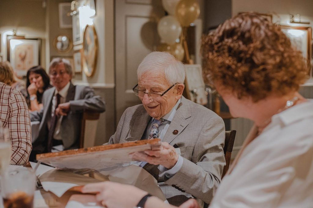 An elderly man joyfully celebrates his birthday with family.